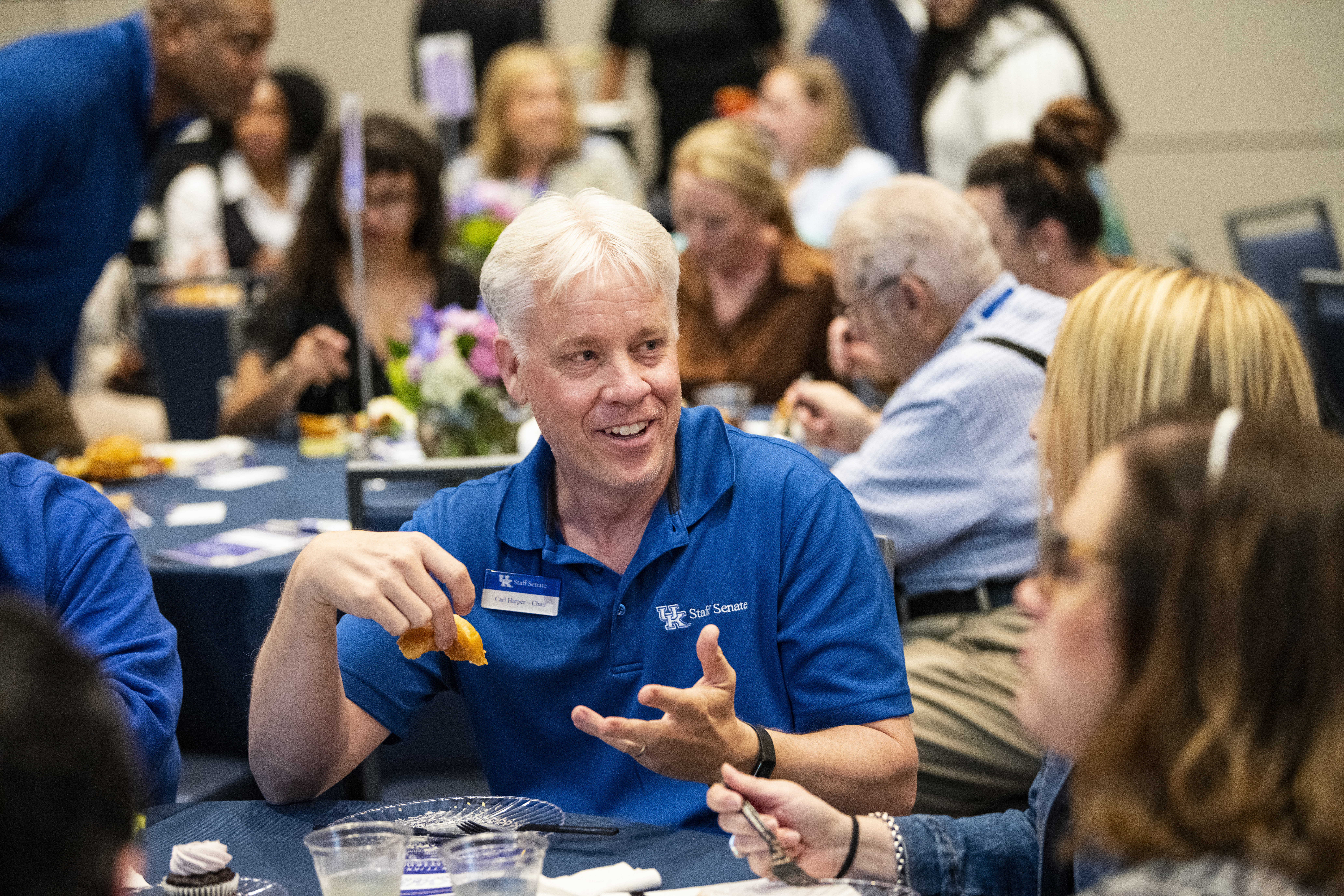 UK Staff Senate Chair Carl Harper talking with people at his table during the Sarah Bennett Holmes Award Luncheon